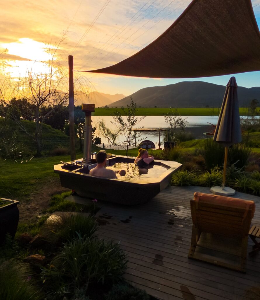 Couple in the wood-fired hot tub at sunset, Wilderness
