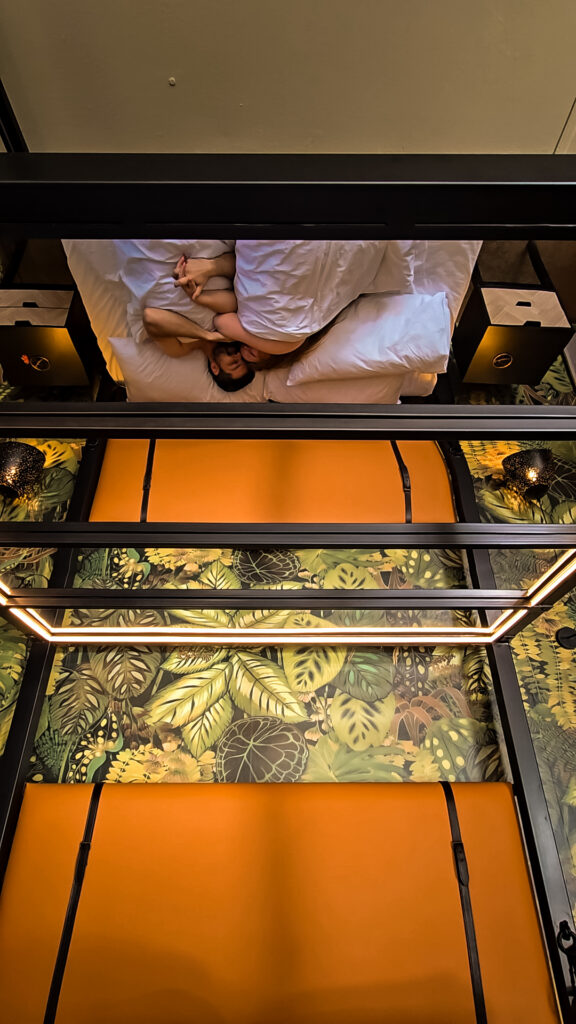 Couple reflected in the mirrored four-poster bed at Naughty by Nature, Wilderness