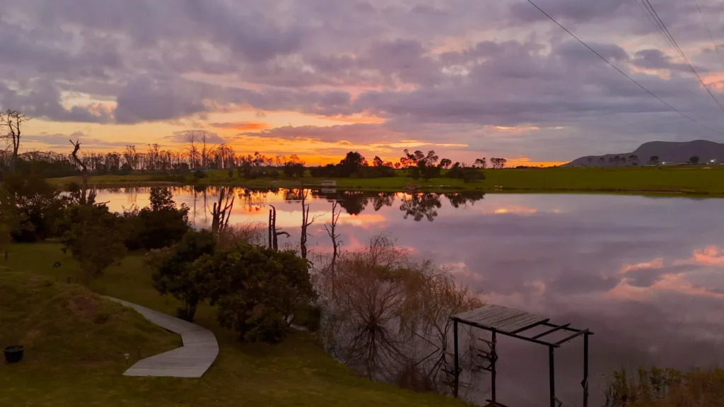 Sunset over the lake and mountains at Naughty by Nature, a private couples cabin in Wilderness on the Garden Route